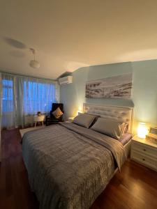 a bedroom with a large bed with a blue wall at Kakavanen’s Sea View apartment in Balchik