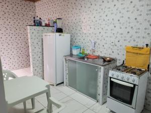 a small kitchen with a stove and a refrigerator at Apartamento com ar e exclusivo, zona sul de Ilhéus, bairro Hernani Sá in Ilhéus