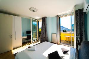 een hotelkamer met een bed en een groot raam bij Montebello Lake in Lecco