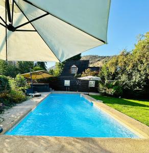 a large blue swimming pool with an umbrella at Descanso Urbano in Santiago