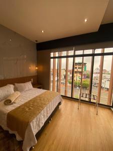 a bedroom with a large bed and large windows at Hotel Casino GRAN AVENIDA in Barrancabermeja