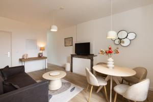 una sala de estar con una mesa y un sofá en MarQue Néo Art, en Carcassonne