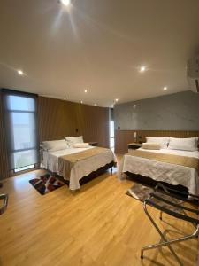 a room with two beds in a room with wooden floors at Hotel Casino GRAN AVENIDA in Barrancabermeja