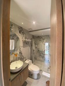 a bathroom with a toilet and a sink at Hotel Casino GRAN AVENIDA in Barrancabermeja