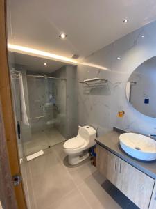 uma casa de banho com um WC, um chuveiro e um lavatório. em Hotel Casino GRAN AVENIDA em Barrancabermeja