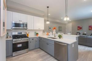 a large kitchen with white cabinets and stainless steel appliances at PRISTINE 3 bdrm - Garage Parking - Close to UPENN in Philadelphia