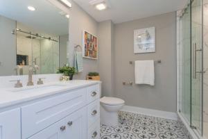 a white bathroom with a toilet and a glass shower at PRISTINE 3 bdrm - Garage Parking - Close to UPENN in Philadelphia
