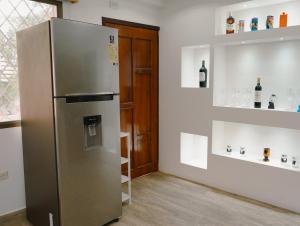 een roestvrijstalen koelkast in een kamer met planken bij Suite departamento al pie de la playas con Aire acondicionado in Playas
