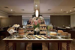 a table with cakes and other desserts on it at Hotel Mont Blanc Premium in Ribeirão Preto +25 photos