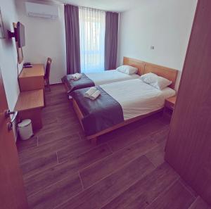 a hotel room with a bed and a desk and a window at Hotel Tabor in Sežana