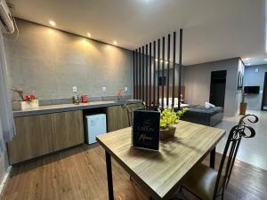cocina y sala de estar con mesa y libro en Motel Orion - Belo Horizonte, en Belo Horizonte