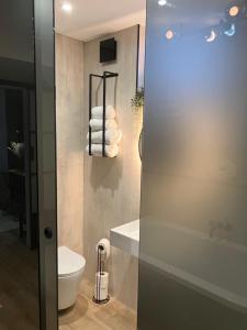 a bathroom with a tub and a toilet and a sink at Abbey Court Guest House in Carlisle