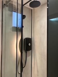 a shower with a glass door with a soap dispenser at Abbey Court Guest House in Carlisle