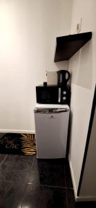 a small white refrigerator with a microwave on top of it at Suite Love Room in Marseille