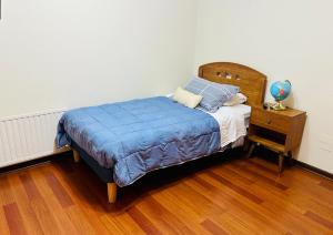 a bedroom with a bed with a wooden headboard and a night stand at Descanso Urbano in Santiago