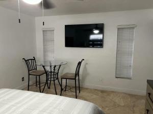 a bedroom with a table and chairs and a tv at Cozy lakeside suite with private bath & entrance in Pembroke Pines