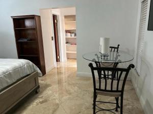 a bedroom with a glass table and a bed at Cozy lakeside suite with private bath & entrance in Pembroke Pines