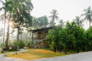 dom na środku parku z palmami w obiekcie Tekkawatta w Kolombo