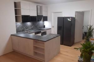 a kitchen with a black refrigerator in a room at Stilvolle Stadtoase nähe Prater inkl. Whirpool in Vienna