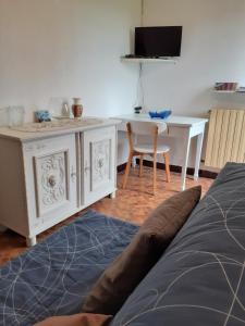 Ponches-EstruvalLes Kiwis的一间卧室配有一张床、一张书桌和一台电视。