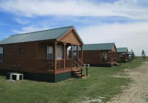uma fileira de cabanas de madeira na praia em Lakeside Motel, Cabins and RV em Kingston