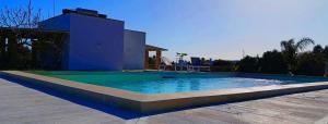 a swimming pool in front of a house at Trullomio in Torre Suda