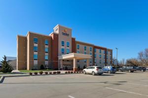 Comfort Inn & Suites Newcastle - Oklahoma City في Newcastle: مبنى مكتب مع سيارة متوقفة في موقف للسيارات