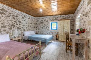 a bedroom with two beds and a table in a room at La Maison Bleue in Zaros