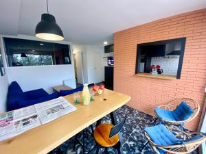 a dining room with a wooden table and blue chairs at Apartament per parelles reformat amb piscina in Calella de Palafrugell
