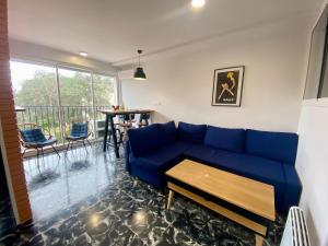 a living room with a blue couch and a table at Apartament per parelles reformat amb piscina in Calella de Palafrugell