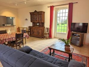 ein Wohnzimmer mit einem blauen Sofa und einem Tisch in der Unterkunft Gîte Cherves-Richemont, 3 pièces, 5 personnes - FR-1-653-205 in Cherves-de-Cognac