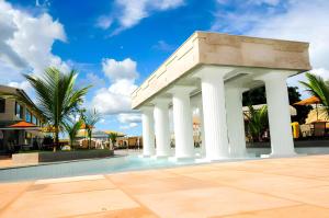 un bâtiment blanc avec colonnes à côté d'une piscine dans l'établissement Lacqua Diroma 1 2 3 4 5, à Caldas Novas