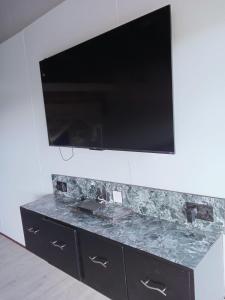 einen TV an einer Wand mit einer Marmoroberfläche in der Unterkunft Kitumo Mara Lodges in Mara Simba