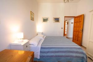een slaapkamer met een bed met een blauw en wit gestreepte deken bij Elide Apartments - Comfort in Polignano a Mare