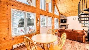 a dining room with a table and chairs and a couch at Muskoka Lakefront 3-bdrm Chalet in Port Carling