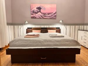 ein Schlafzimmer mit einem großen Bett und einem Gemälde an der Wand in der Unterkunft Apartment am Schloss-Park Wiesbaden Biebrich am Rhein in Wiesbaden