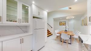 cocina con armarios blancos y mesa de madera en Newly renovated & spacious 4 BDR house in Toronto, en Toronto