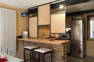 a kitchen with a counter with stools and a refrigerator at B&B Casa V-Ale in Collegno
