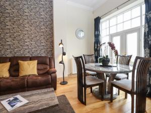 a living room with a couch and a table at 5 Ladstock Hall in Keswick