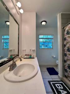 a white bathroom with a sink and a mirror at Entire Waterfront House in Turtle Cove