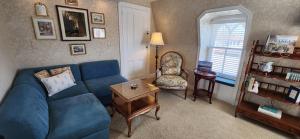a living room with a blue couch and a chair at The Mason Cottage Downtown in Cape May