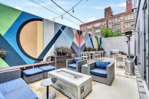 a rooftop patio with furniture and a mural at City View 1BR w/ Patio by Lively Italian Market in Philadelphia