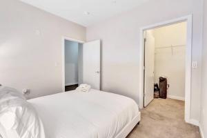 a white bedroom with a bed and a closet at City View 1BR w/ Patio by Lively Italian Market in Philadelphia