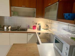 una cocina con armarios blancos y fregadero en Casa Beraldini, en Verona