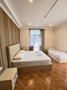 1 dormitorio con 2 camas y ventana en IRISE en Batumi