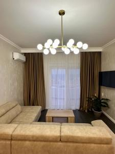 a living room with a couch and a chandelier at Apartmani Sunce in Bar