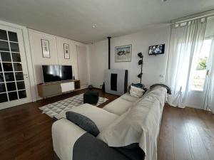 sala de estar con sofá grande y TV en Alloggio turistico-Charming Nature House en Ronciglione