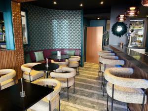 um bar com mesas e bancos num restaurante em Cit'Hotel Grand Hotel L'Etape em Saint-Flour