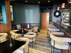 a bar with tables and stools in a restaurant at Cit'Hotel Grand Hotel L'Etape in Saint-Flour