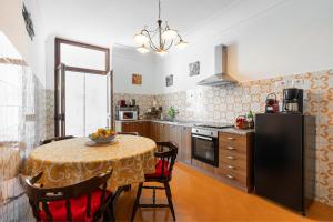 uma cozinha com uma mesa com cadeiras e um frigorífico em Mimì Junior home, central sea view apartment em Praiano